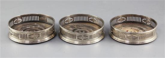 A set of three George III pierced and bright cut silver bottle coasters, maker probably Robert Hennell II, 12cm.